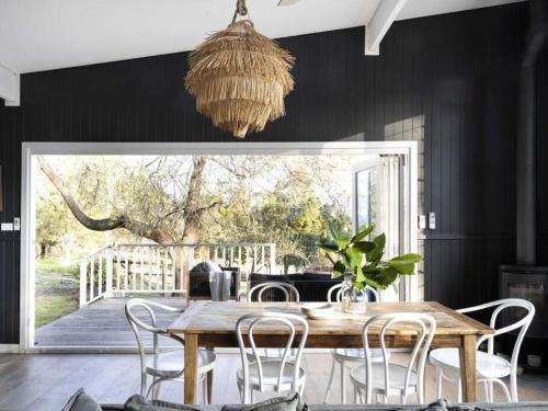 a dining room with a wooden table and chairs at Jamberoo Valley Farm in Jamberoo