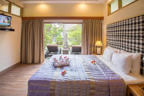 um quarto com uma cama grande com flores em Bayside Bungalows em Candidasa