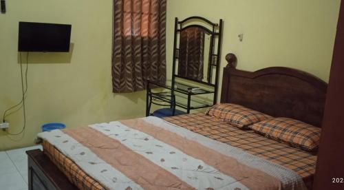 sypialnia z łóżkiem i lustrem w obiekcie Griya Istana 1 w mieście Surakarta