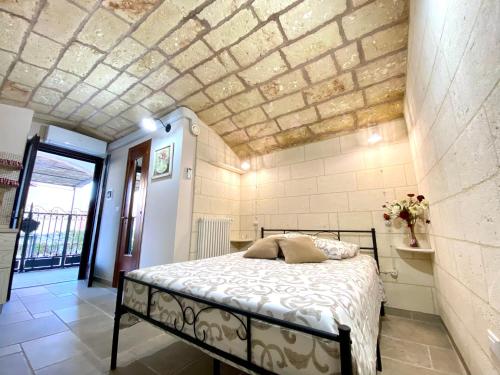 a bedroom with a bed and a brick wall at L' ATTICO CastroSalento in Castro di Lecce