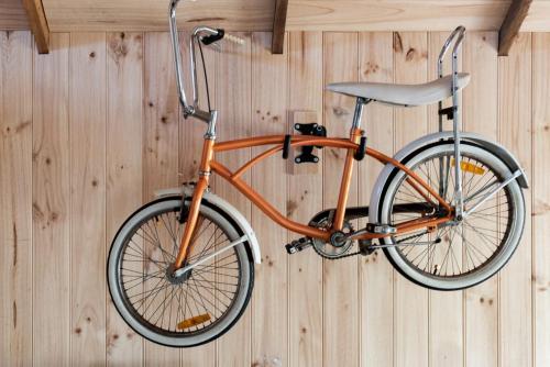 an orange bike is hanging on a wall at Rustic Barn by the Bay in Low Head