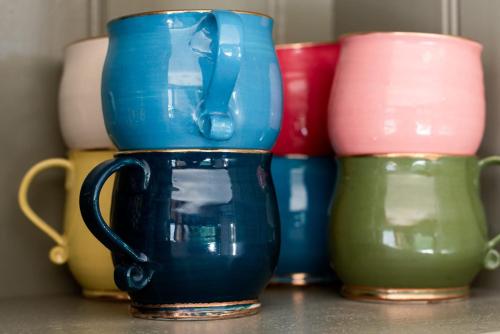 a group of different colored vases sitting on a table at Rustic Barn by the Bay in Low Head