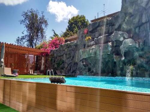 a swimming pool with a waterfall in a yard at PrideInn Azure Hotel Nairobi Westlands in Nairobi