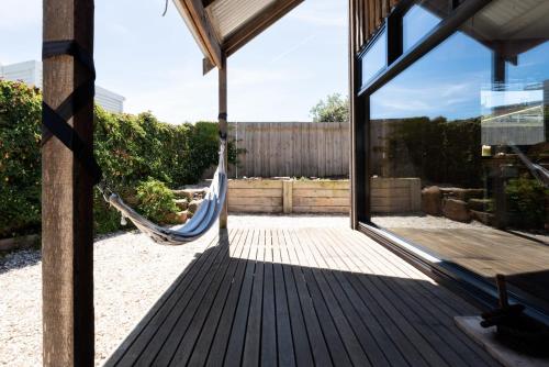 a porch with a hammock in a house at Rustic Barn by the Bay in Low Head
