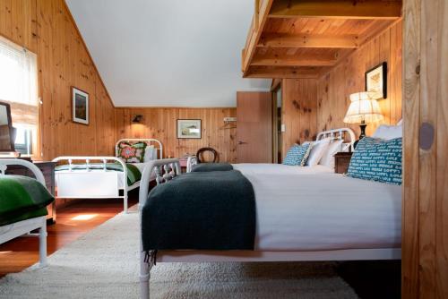 a bedroom with a large bed and wooden walls at Rustic Barn by the Bay in Low Head