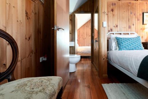 a bedroom with a bed and a toilet in a room at Rustic Barn by the Bay in Low Head