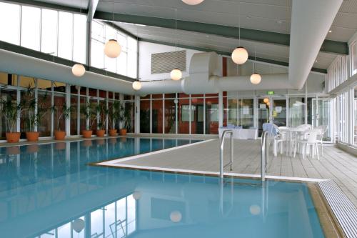 a swimming pool with blue water and plants in a building at Horizons 404 in Jindabyne