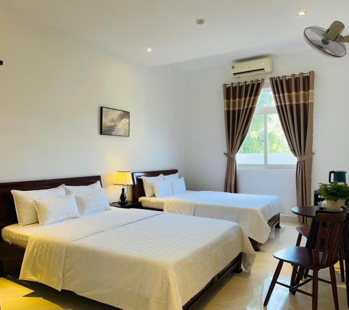 Habitación de hotel con 2 camas y ventana en KHÁCH SẠN ROMO, en Quảng Ngãi