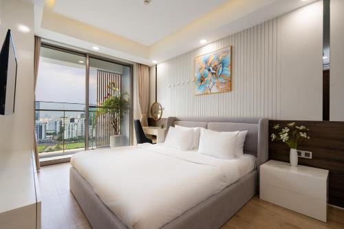 Un dormitorio con una gran cama blanca y una ventana en Convinia Luxury The Peak Midtown, en Ho Chi Minh