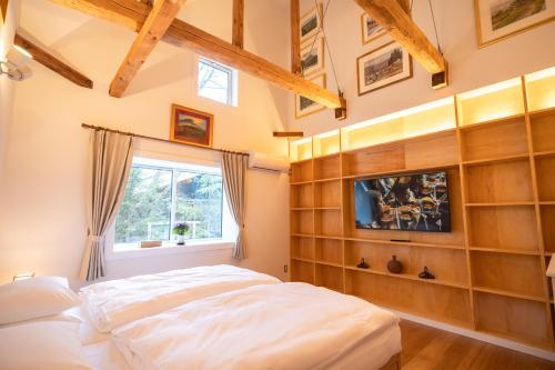 Un dormitorio con una cama grande y una ventana en Snow Horizon, en Hakuba