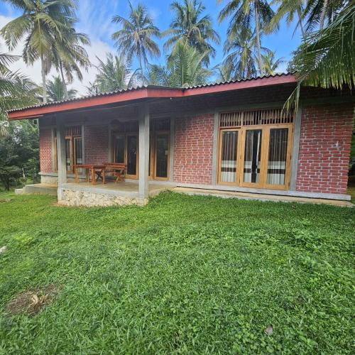 a red brick house with a picnic table in a yard at THE HIDEOUT KURUNEGALA in Kurunegala