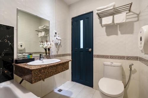 ein Badezimmer mit einem WC, einem Waschbecken und einem Spiegel in der Unterkunft La Casona Boutique Hotel in Ho-Chi-Minh-Stadt