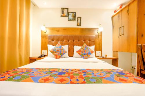 ムンバイにあるFabHotel Anam Internationalのベッドルーム1室(カラフルなベッドカバー付)
