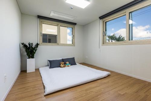 En eller flere senge i et værelse på Seogwipo Donnaeco Pension