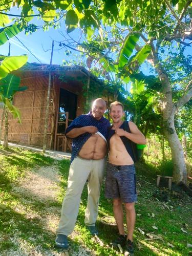 a man and a woman standing in front of a house at Sobral Rice Terraces View in Antihon