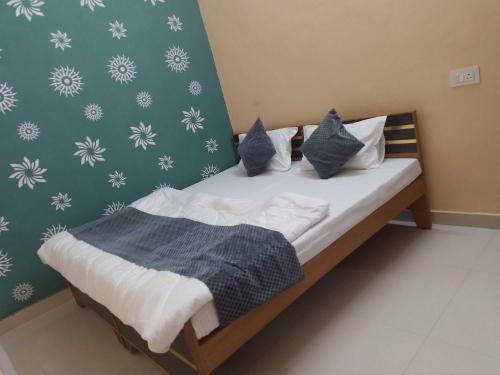 Bett mit blauen und weißen Kissen in einem Zimmer in der Unterkunft OYO Hotel Shivay in Varanasi