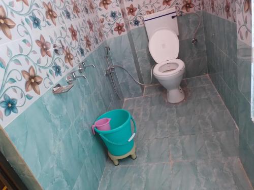 a bathroom with a toilet and a bucket in it at OYO Hotel Shivay in Varanasi