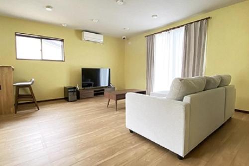 a living room with a white couch and a television at Wine Inn Tomu - Vacation STAY 42199v in Katsunuma