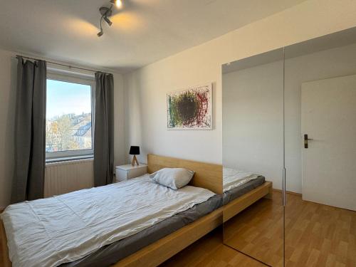 Schlafzimmer mit einem Bett mit Glaswand in der Unterkunft Lichtdurchflutete 82m2-Wohnung - 2 Schlafzimmer - im Zentrum Hagens in Hagen