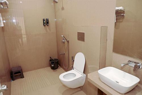 La salle de bains est pourvue d'une douche, de toilettes et d'un lavabo. dans l'établissement Baroda Banquets, à Vadodara