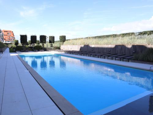 une grande piscine d'eau bleue dans l'établissement Jalina with swimming pool, à Nieuport