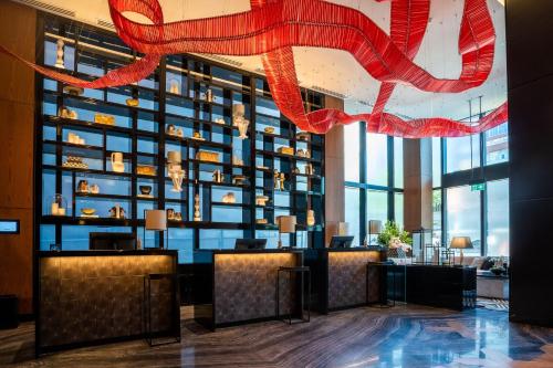 a lobby of a hotel with a large wall of windows at Sofitel Adelaide in Adelaide