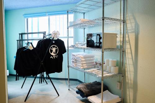 a room with a rack with a shirt with a skull on it at Hotel CABANA カバナ 宮古島 in Miyako Island