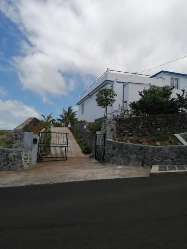 a white house with a gate and a stone wall at Ô Bercail du Sud-Hibiscus chez Jeannette in Mt Bois Noir