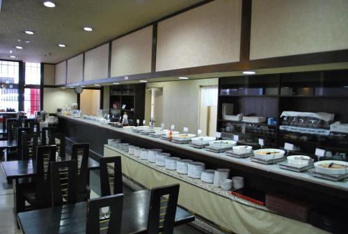 un restaurante con una barra larga con platos en Hotel Alpha-One Nagaoka, en Nagaoka