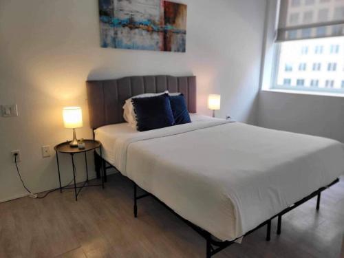 a bedroom with a large white bed with two lamps at 629 Lofts 810 - A KCM Property in Cleveland