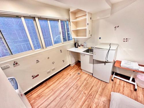 una pequeña cocina con armarios blancos y escritorio en Jacky's House Ximen en Taipéi