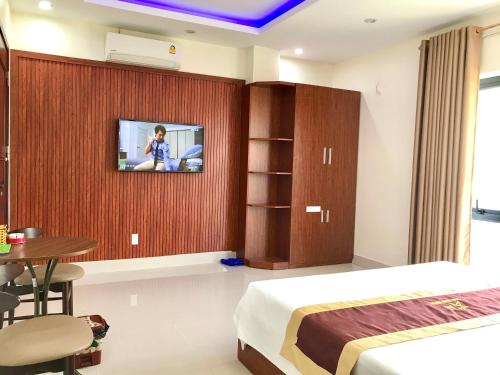 een slaapkamer met een bed en een tv aan de muur bij SAO MAI Dien Chau Hotel in Diễn Châu