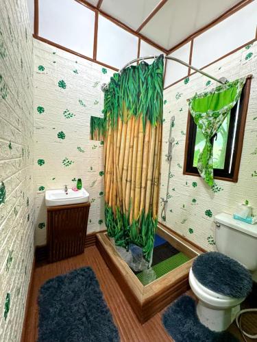 a bathroom with a toilet and a bamboo shower curtain at Sobral Rice Terraces View in Antihon