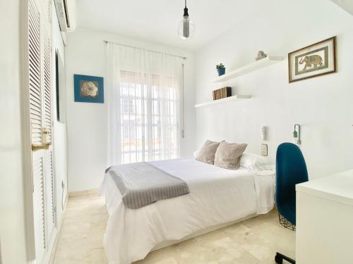una camera bianca con un letto e una finestra di Apartamento Andalucía Centro III ad Antequera