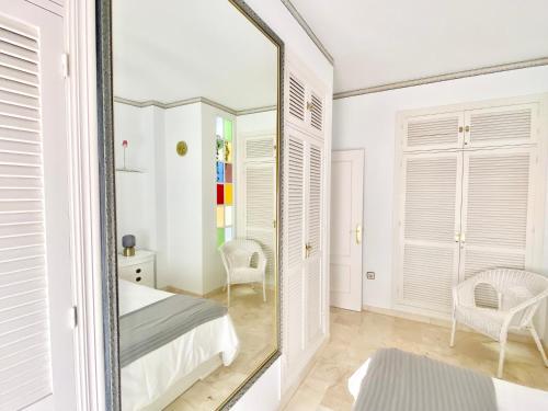 uno specchio in una camera da letto con un letto e una sedia di Apartamento Andalucía Centro III ad Antequera