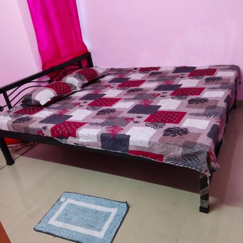 a bed with a quilt on it in a room at Piyari Home stay 2 in Kolkata