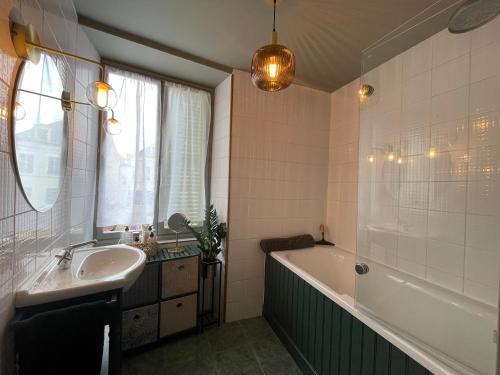 La salle de bains est pourvue d'une baignoire et d'un lavabo. dans l'établissement Maison Les Fossiles, à Sancerre