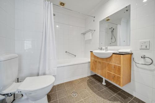 Center 1-Bed with Sauna, Gym, BBQ & Parking في كانبرا: حمام مع مرحاض ومغسلة وحوض استحمام