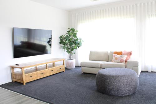 a living room with a couch and a tv at Bottlebrush Moama in Moama