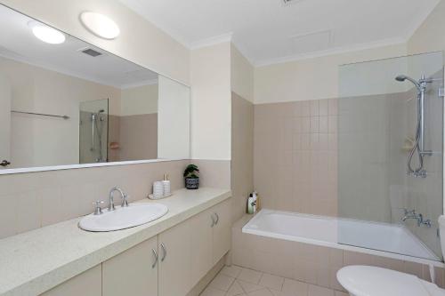 a bathroom with a sink and a tub and a mirror at 2BDR 1BTH - James Street Magic in Perth