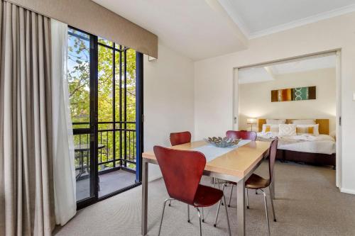a dining room with a table and chairs and a bedroom at 2BDR 1BTH - James Street Magic in Perth