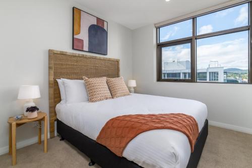um quarto com uma cama grande e 2 janelas em Spacious 2-Bed, Stunning Views in Central Canberra em Kingston 