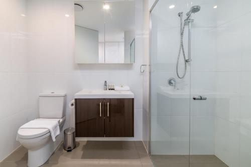 y baño con aseo, ducha y lavamanos. en Spacious 2-Bed, Stunning Views in Central Canberra, en Kingston 