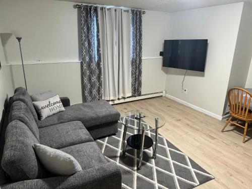 sala de estar con sofá y TV de pantalla plana en North Star Place 1 en Fairbanks