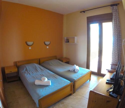 a bedroom with two twin beds with towels on them at Kostas House in Gerakini
