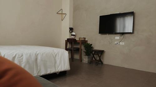 a room with a bed and a flat screen tv at 木子寓所 Moozhouse in Magong