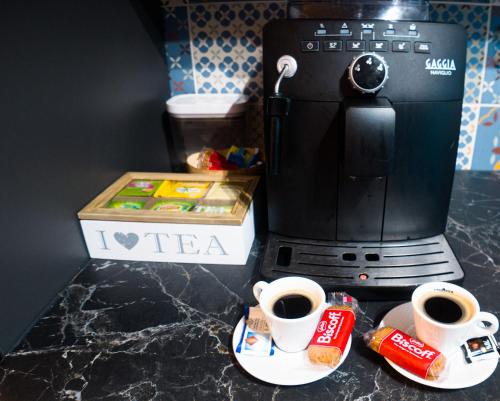 two cups of coffee sitting next to a coffee maker at Villa Osao Panahy in Le Patelin