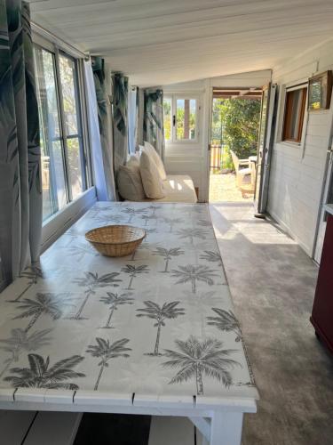d'un salon avec une table et des palmiers. dans l'établissement BUNGALOW 60 M2, à Roquebrune-sur Argens