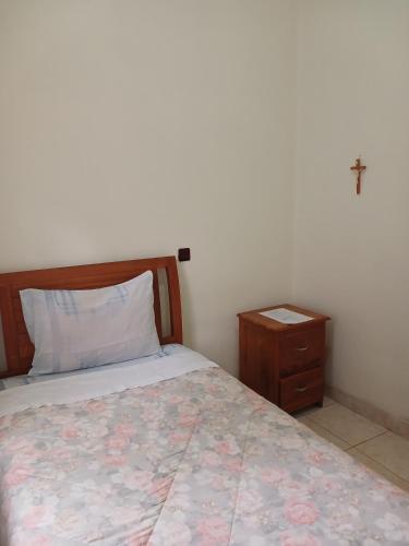 a bedroom with a bed and a night stand at Hotel MBC Ruteng in Ruteng