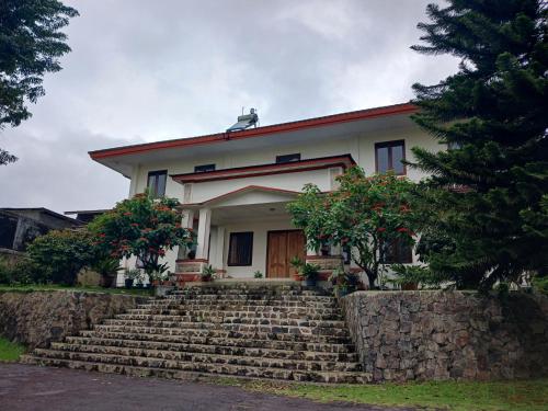 a white house with stairs in front of it at Hotel MBC Ruteng in Ruteng